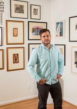 Adam Werth, president of the Print Club of Rochester, in Phillips Fine Art & Frame gallery, which houses the collection of the Print Club of Rochester. - PHOTO BY JOHN SCHLIA