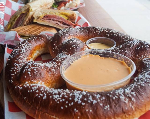 A sizable pretzel with cheese sauce and mustard at TinRoof Bar & Grill. - PHOTO BY JACOB WALSH