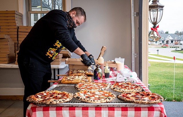 Jim Zobel of Doughboyz serves up pizza at a pop-up location in Greece. - PHOTO BY JACOB WALSH