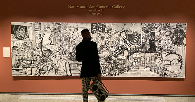 Artist Shawn Dunwoody views his painting, "Unfinished Business," which reflects on moments of social uprisings in Rochester, and is on loan to the Memorial Art Gallery through August. - PHOTO COURTESY RACHAEL BROWN / MEMORIAL ART GALLERY