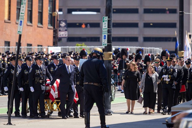 The casket carrying Officer Anthony Mazurkiewicz is escorted by officers past family outside Blue Cross Arena. - PHOTO BY LAUREN PETRACCA