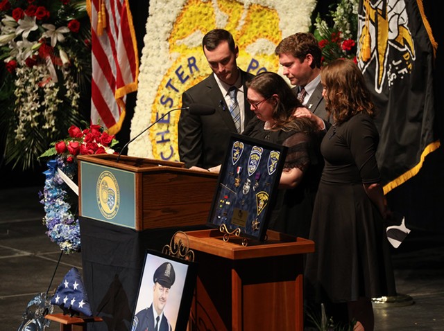 Rochester Police Officer Anthony Mazurkiewicz had four children: Brent Mazurkiewicz, Bradley Mazurkiewicz, Brooks Balcer, and Bryce Mazurkiewicz. In the foreground eulogizing her father is Bryce, surrounded by her siblings. - PHOTO BY MAX SCHULTE