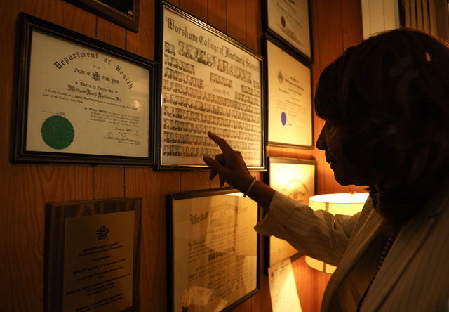 Diplomas, credentials, and other accolades adorn the wood-paneled walls of Millard E. Latimer & Son Funeral Directors. - PHOTO BY MAX SCHULTE