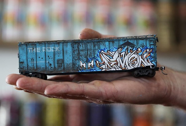 Alex Price displays a model train freight car he weathered and graffitied with his tag, "Demon." - PHOTO BY MAX SCHULTE