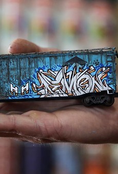 Alex Price displays a model train freight car he weathered and graffitied with his tag, "Demon."