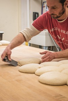 An Amazing Grains worker prepares bread dough.